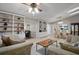 Spacious living room featuring built-in bookshelves, tile flooring, and comfortable seating arrangement at 942 Cinnamon Ct, Altamonte Springs, FL 32714