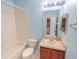Bathroom with single sink vanity, updated light fixture, and tub with shower at 9620 Doris Ln, Orlando, FL 32829
