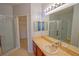 Bright bathroom with a large mirror, cherry vanity and a walk-in shower offering a spa-like experience at 9620 Doris Ln, Orlando, FL 32829
