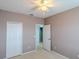 A cozy bedroom with neutral walls, carpet, a ceiling fan, and a double-door closet at 9620 Doris Ln, Orlando, FL 32829