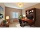 A staged bedroom has a large desk with hutch, side table, lamps, a picture window, and neutral color scheme at 9620 Doris Ln, Orlando, FL 32829
