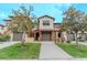 Charming townhome showcasing a well-manicured lawn and neutral-toned exterior, complemented by lovely trees at 9620 Doris Ln, Orlando, FL 32829
