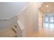 Bright hallway with stairs and entrance to an open living area featuring tile floors and natural light at 9620 Doris Ln, Orlando, FL 32829