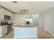 A bright kitchen with stainless steel appliances, an island with a sink, and lots of storage at 9620 Doris Ln, Orlando, FL 32829
