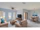 Bright, staged living room features sleek ceiling fan, blond laminate flooring, and stylish neutral color scheme at 9620 Doris Ln, Orlando, FL 32829