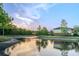 Scenic view of community pond reflecting the sky, surrounded by lush trees, and nearby residences at 9620 Doris Ln, Orlando, FL 32829