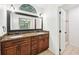 Well-lit bathroom with dual sinks, granite countertop, decorative mirror and lighting at 1042 Catfish Creek Ct, Oviedo, FL 32765