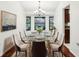 Elegant dining room with glass table, upholstered chairs, and decorative chandelier at 1042 Catfish Creek Ct, Oviedo, FL 32765