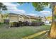 An angled view of the front of the house with well-maintained landscaping and some large trees at 1042 Catfish Creek Ct, Oviedo, FL 32765