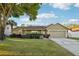 Charming single-story home with a well-manicured lawn, two-car garage, and mature tree providing shade at 1042 Catfish Creek Ct, Oviedo, FL 32765