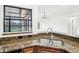 Kitchen sink with view of the screened-in lanai and granite countertops at 1042 Catfish Creek Ct, Oviedo, FL 32765