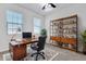 Home office with a modern desk, shelving unit, and plenty of natural light at 1232 Celery Oaks Ln, Sanford, FL 32771