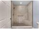 Modern tiled walk-in shower featuring a built-in bench, grab bar, and elegant fixtures at 139 Durham Pl, Longwood, FL 32779