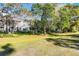 Exterior view of the condo building and a large, well-maintained lawn area with mature trees at 139 Durham Pl, Longwood, FL 32779