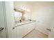 Bright bathroom featuring a double vanity with granite countertops and a large mirror at 1447 Kissimmee Way, Kissimmee, FL 34759