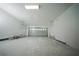 Spacious garage with white walls, concrete floor, and an overhead door at 1447 Kissimmee Way, Kissimmee, FL 34759