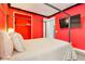 Bright red bedroom features a comfortable bed, closet, and television, creating a stylish and inviting space at 1468 Fairview Cir, Reunion, FL 34747