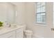 Clean powder room featuring a white vanity, quartz countertop, and a large window at 1468 Fairview Cir, Reunion, FL 34747