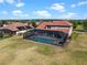 Aerial view of a screened pool and outdoor space along with a beautiful home with lush landscaping at 14823 Borromini St, Montverde, FL 34756