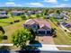 Aerial view showcasing a two-story home with a three-car garage and brick-paved driveway at 14823 Borromini St, Montverde, FL 34756