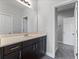 Bathroom features a vanity with dark cabinets, a large mirror, and neutral gray paint at 14823 Borromini St, Montverde, FL 34756