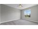 Empty bedroom with neutral colored walls and carpet with a large window offering views of the neighborhood at 14823 Borromini St, Montverde, FL 34756