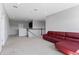 Upstairs bonus room features a modern red leather sofa with a staircase and landing in view at 14823 Borromini St, Montverde, FL 34756