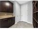 Stylish butler pantry featuring stone backsplash, granite countertop, and dark wood cabinets at 14823 Borromini St, Montverde, FL 34756