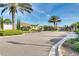 Gated community entrance featuring meticulously landscaped grounds and beautiful palm trees on a sunny day at 14823 Borromini St, Montverde, FL 34756