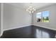 Bright dining room featuring dark wood floors, a modern chandelier, and a large window with a view of the outdoors at 14823 Borromini St, Montverde, FL 34756