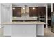 Close-up of a kitchen island with granite countertops, stainless steel sink, and dark wood cabinetry, perfect for cooking at 14823 Borromini St, Montverde, FL 34756