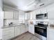 Modern kitchen with stainless steel appliances, granite countertops, and white cabinets at 1503 Holly Rd, Lakeland, FL 33801