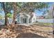 View of the home's backyard with mature trees, a new patio, and white vinyl fence at 155 Aunt Polly Ct, Orlando, FL 32828