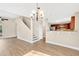 Open living space featuring wood-look floors, staircase, and a view into the kitchen at 155 Aunt Polly Ct, Orlando, FL 32828