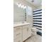 Bright bathroom features modern fixtures, clean lines, and a stylish striped shower curtain at 15837 Sweet Lemon Way, Winter Garden, FL 34787