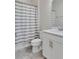 Stylish bathroom featuring a vanity with a white countertop, single sink, and white and gray shower curtain at 15837 Sweet Lemon Way, Winter Garden, FL 34787