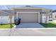 Two car garage featuring an asphalt driveway and trimmed shrubs at 15837 Sweet Lemon Way, Winter Garden, FL 34787