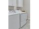 Functional laundry room with modern appliances and sleek white cabinetry at 15837 Sweet Lemon Way, Winter Garden, FL 34787