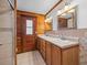 Bathroom featuring a double vanity with wood cabinets, neutral countertops, and wood paneled walls at 16510 Quarter Horse Ct, Montverde, FL 34756