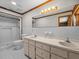 Bright bathroom with a dual sink vanity, a large mirror, and a shower with toilet at 16510 Quarter Horse Ct, Montverde, FL 34756