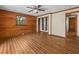 Charming bedroom featuring wood paneling, ceiling fan, window, closet, and wood-look laminate flooring at 16510 Quarter Horse Ct, Montverde, FL 34756