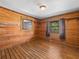 Charming bedroom featuring wood paneling, a window, and wood-look laminate flooring at 16510 Quarter Horse Ct, Montverde, FL 34756