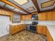 Well-lit kitchen boasts wood cabinets, modern appliances, contrasting countertops, and patterned flooring at 16510 Quarter Horse Ct, Montverde, FL 34756