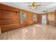 Living room featuring wood paneling, ceiling fan, multiple windows, and tile flooring at 16510 Quarter Horse Ct, Montverde, FL 34756