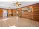 Living room featuring wood paneling, ceiling fans, and tile flooring at 16510 Quarter Horse Ct, Montverde, FL 34756