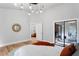 Light-filled main bedroom featuring wood floors, stylish decor, and access to a sunroom at 1756 Waterbeach Ct, Apopka, FL 32703