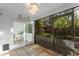 Bright sunroom with views of lush greenery, featuring tile floors and glass doors at 1756 Waterbeach Ct, Apopka, FL 32703