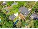 Aerial view of a lush estate featuring a main house, a separate structure, a pool, and manicured landscaping at 1911 Stonehurst Rd, Winter Park, FL 32789