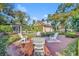 Beautiful backyard with a fire pit, pool, lush landscaping, and a detached garage creating an outdoor oasis at 1911 Stonehurst Rd, Winter Park, FL 32789