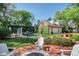 Beautiful backyard with a pool, swing, outdoor fireplace, red brick patio and a garage covered in green vines at 1911 Stonehurst Rd, Winter Park, FL 32789